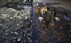 A boy takes bath from a water tap near a polluted water channel in Kolkata, India.