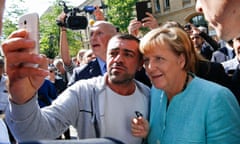 A migrant takes a selfie with Angela Merkel