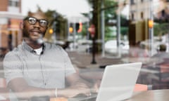 Black man using laptop in coffee shop<br>Young man on laptop on coffee shop