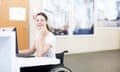 Young female university student using wheelchair using computer at desk