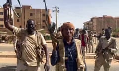 Semi-uniformed men fire their AK-47 assault rifles in the air in a city