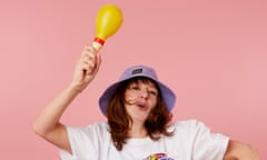 Zoe Williams shaking maracas against a pink background