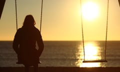 Lonely woman watching sunset alone in winter on the beach