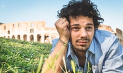 A man sitting on the grass near a Roman amphitheatre