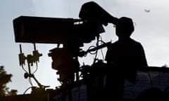 A camera operator at a football stadium