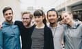 Group portrait of confident male and female computer programmers standing together in office