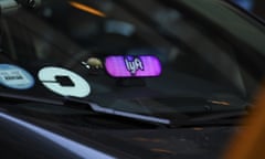 A car showing a logo for lyft and uber in the windshield