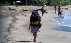 Backpacker walks along the beach at Playa Samara Costa Rica