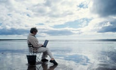 Woman using laptop on a beach