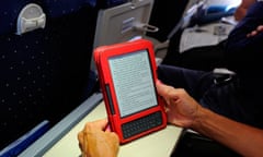 An airplane passenger reading a Kindle