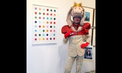 A visitor poses near a Damien Hirst piece at the Nitsch/Paragon gallery at Art Basel Miami Beach