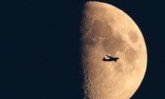 Plane flies in front of the moon