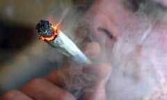 A file photo of an unidentified man smoking a cannabis cigarette at a house in London