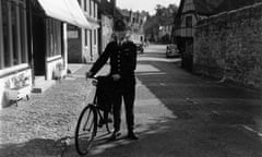 A country police constable on bicycle duty in the Surrey village of Shere