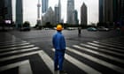 A construction worker looks at Pudong financial district in Shanghai