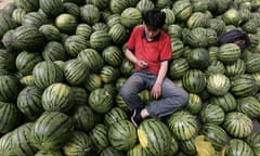 Watermelon vendor uses his mobile phone at a market in Taiyuan