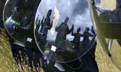 Eco-activists reflected in a Police riot shield  at the Climate Camp near Kingsnorth Power Station