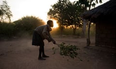 MDG : A young girl sweeps the dust at sunrise at Peter Erionu's compound in Katine