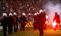 Police try to stop fans going on to the pitch during a match between AIK and Hammarby in 2004