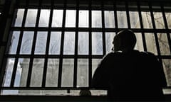 Jail inmate looks out of barred window