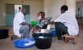 Boulabassi Coumare (middle), head of milk union, and his co-workers pour milk in bags for sale