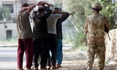 A British soldier guards Iraqi prisoners in the city of Basra in April 2003.SOUTHERN IRAQ.