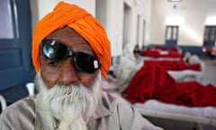 A patient awaits treatment at a hospital after undergoing cataract removals in India