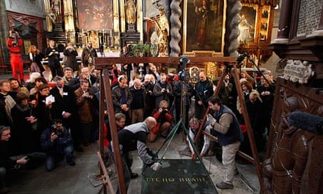 Archeologists lift the tombstone of Tycho Brahe at a church in Prague. 