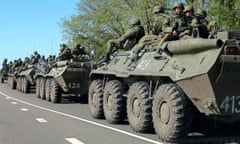Russian servicemen drive armoured personnel carriers