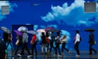 People shelter from the rain under umbrellas on Oxford Street, London