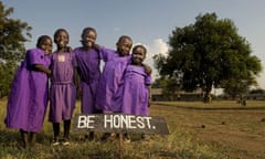 Children from the Tiriri primary school in Katine stand behind one of the many signs on the school grounds that aim to promote good behaviour