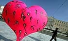 A man walks by a heart-shaped sculpture 