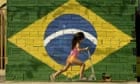 A young girl plays in front of a Brazilian flag in Rio de Janeiro