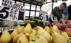 A vendor sells fruit at a market in south London