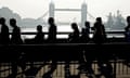 City workers walk across London Bridge on their way to their offices in the financial centre in the City of London