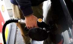 Person fills car at pump in petrol station 