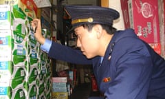 A Chinese trade enforcement officer checks boxes of milk at a shop in Tongzi, Guizhou province