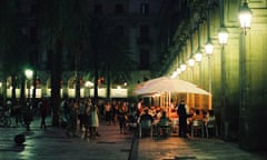 People eating outside at night in Barcelona, Spain.