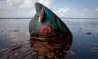 An oil worker's hard hat lies in oil from the Deepwater Horizon spill.