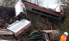 A rail worker stands at the scene of the Virgin train crash at Grayrigg in Cumbria Northern England