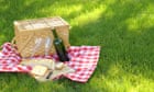 Outdoor picnic with basket, wine, bread and blanket
