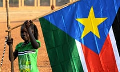 A young girl holds a South Sudan flag