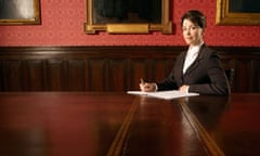 A woman sits alone in a boardroom