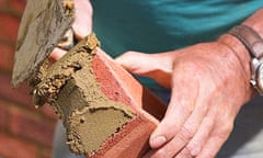 A bricklayer laying a brick