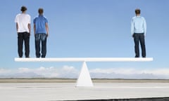 Three men standing on see saw outdoors