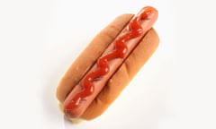 A hot dog in a bun. With ketchup