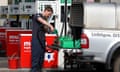 A person fills up fuel containers at a petrol station in Linlithgow as panic-buying spreads
