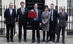 The Chancellor George Osborne with his budget box stands with his treasury team