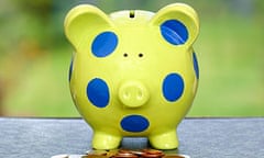 Green and blue spotted piggy bank with coins