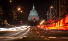 A red traffic light stands in front of the US Capitol building in Washington